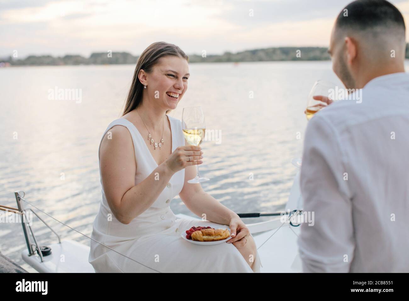 Couple souriant appréciant un verre de vin sur un yacht, Russie Banque D'Images