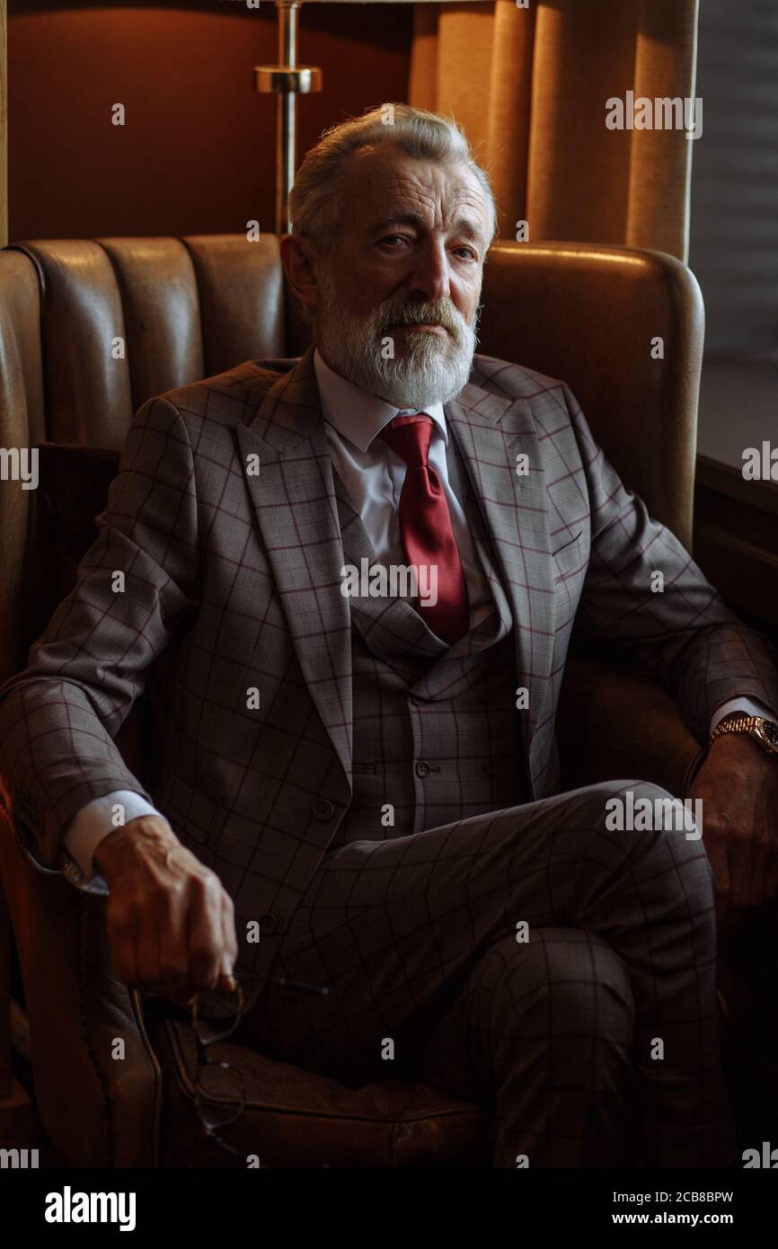 Vieux hommes d'affaires aux cheveux gris vêtus de vêtements et de lunettes,  costume avec cravate rouge, posant à l'intérieur de luxe, regardant la  caméra, bel Photo Stock - Alamy