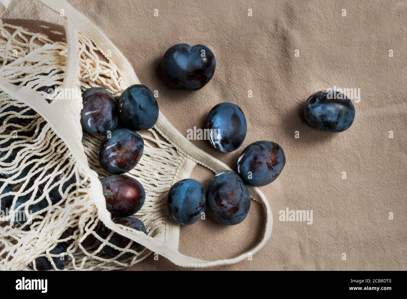 Prunes biologiques dans les sacs d'épicerie à ficelle écologiques réutilisables. Sac à provisions avec fruits. Légumes du marché local. Produits agricoles. Concept de mode de vie écologique. Banque D'Images