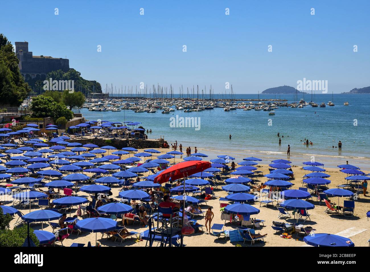 Vue panoramique sur la plage de sable sur la rive du golfe des Poets avec le port, le château et l'île de Tino en arrière-plan, Lerici, italie Banque D'Images