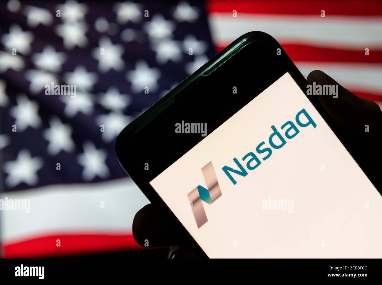 Dans cette illustration, l'indice boursier américain, le logo Nasdaq est visible sur un appareil mobile Android avec le drapeau des Etats-Unis d'Amérique en arrière-plan. Banque D'Images