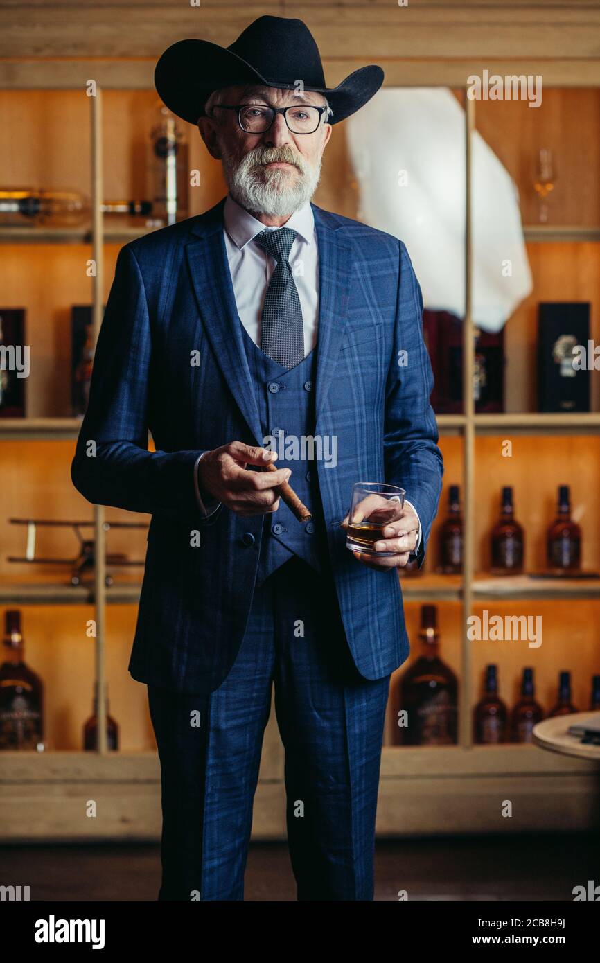 Portrait de l'homme habillé en dandy de la mode élégante hommes s'adapter à  grand chapeau fume le cigare et boissons boissons alcoolisées Photo Stock -  Alamy