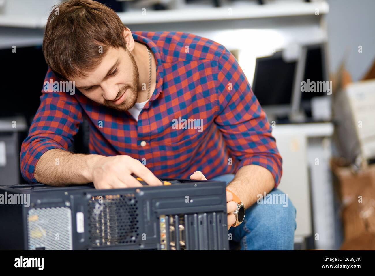 un homme agréable qui démontte une ancienne unité système, gros plan sur une photo. un gars qui remanque un ordinateur dans le bureau Banque D'Images