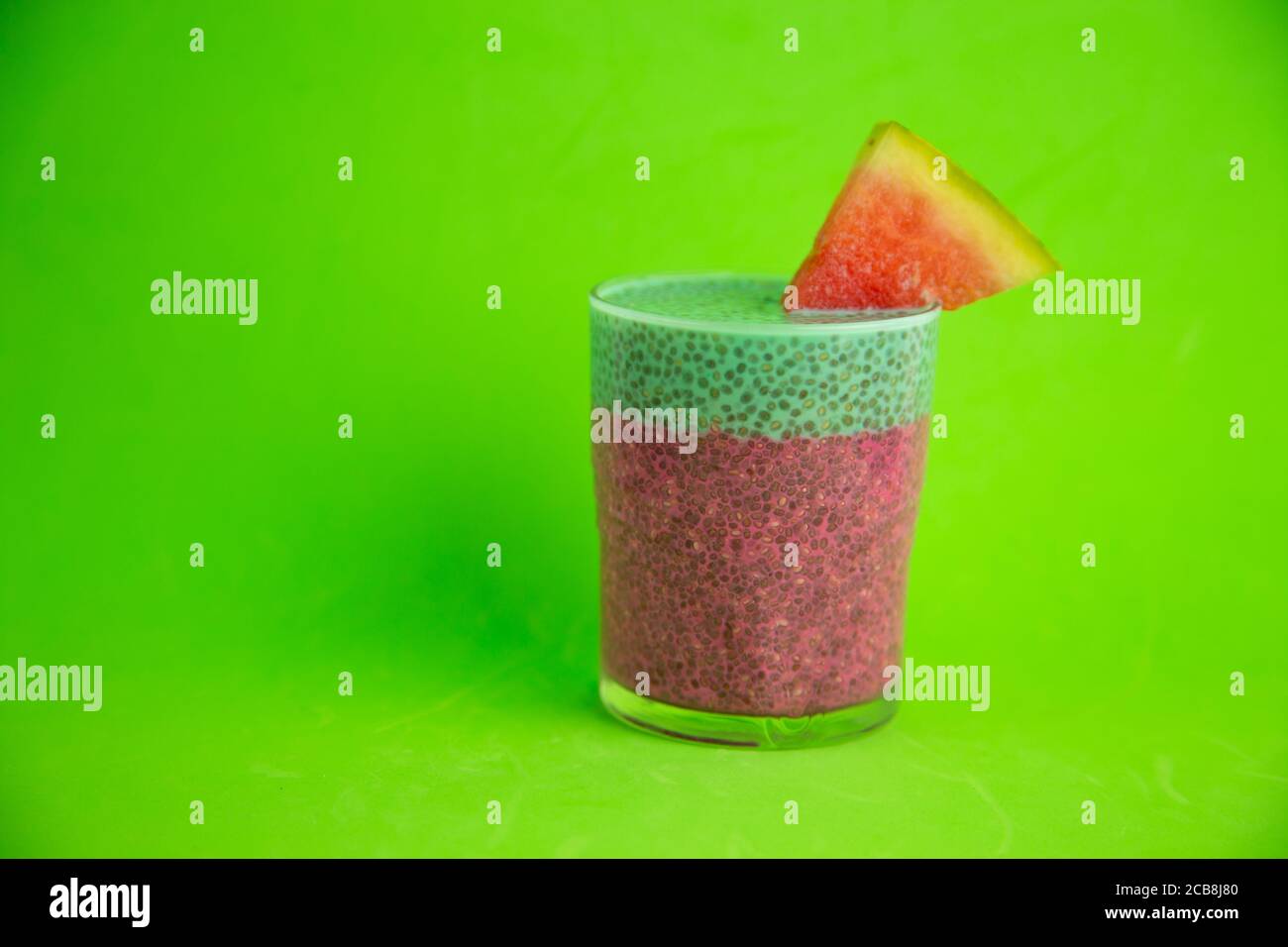 Gros plan d'un verre de gâteau de chia noir avec goût de pastèque sur fond vert Banque D'Images