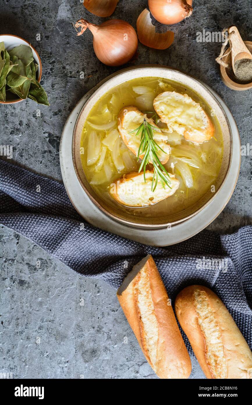 Soupe à l'oignon français classique faite maison dans un bol en céramique, recouvert de tranches de baguette et de fromage râpé Banque D'Images
