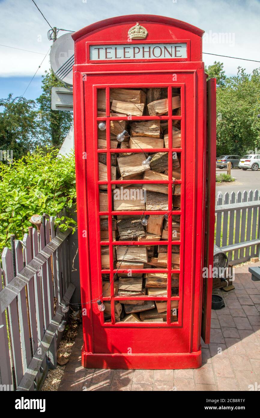 Ancienne borne de cabine de téléphone BT British Telecom traditionnelle rouge Maintenant utilisé comme un hangar de magasin de grumes aux Shepherds Hutte maison publique dans le village d'Ewelme Banque D'Images