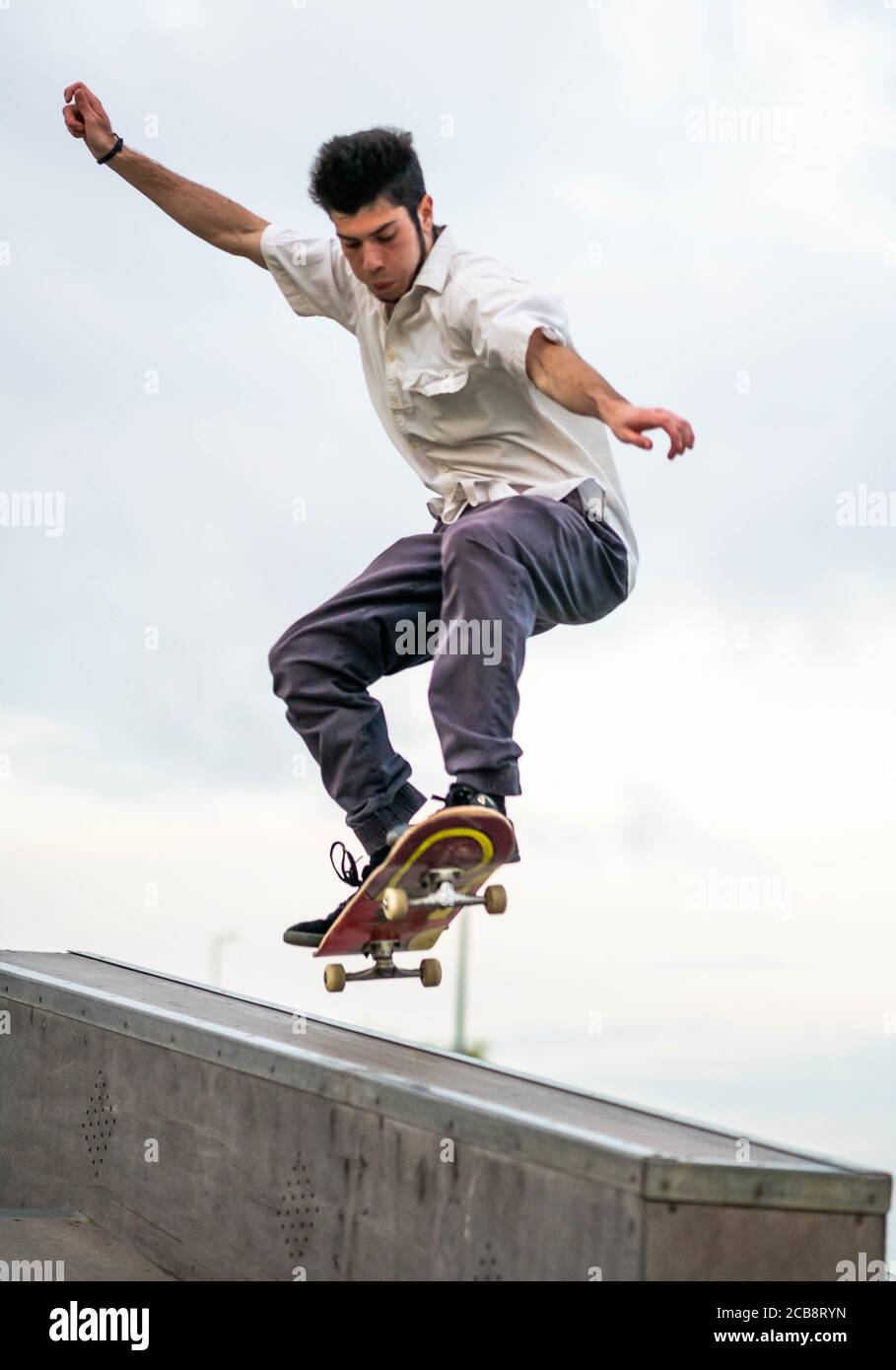 Photo verticale d'un homme européen qui saute sur un skateboard dans un  parc de skate Photo Stock - Alamy