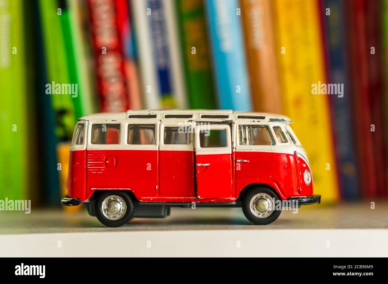 POZNQ, POLOGNE - 26 juillet 2020: Volkswagen Van Samba jouet modèle bus sur une étagère blanche avec des livres. Banque D'Images