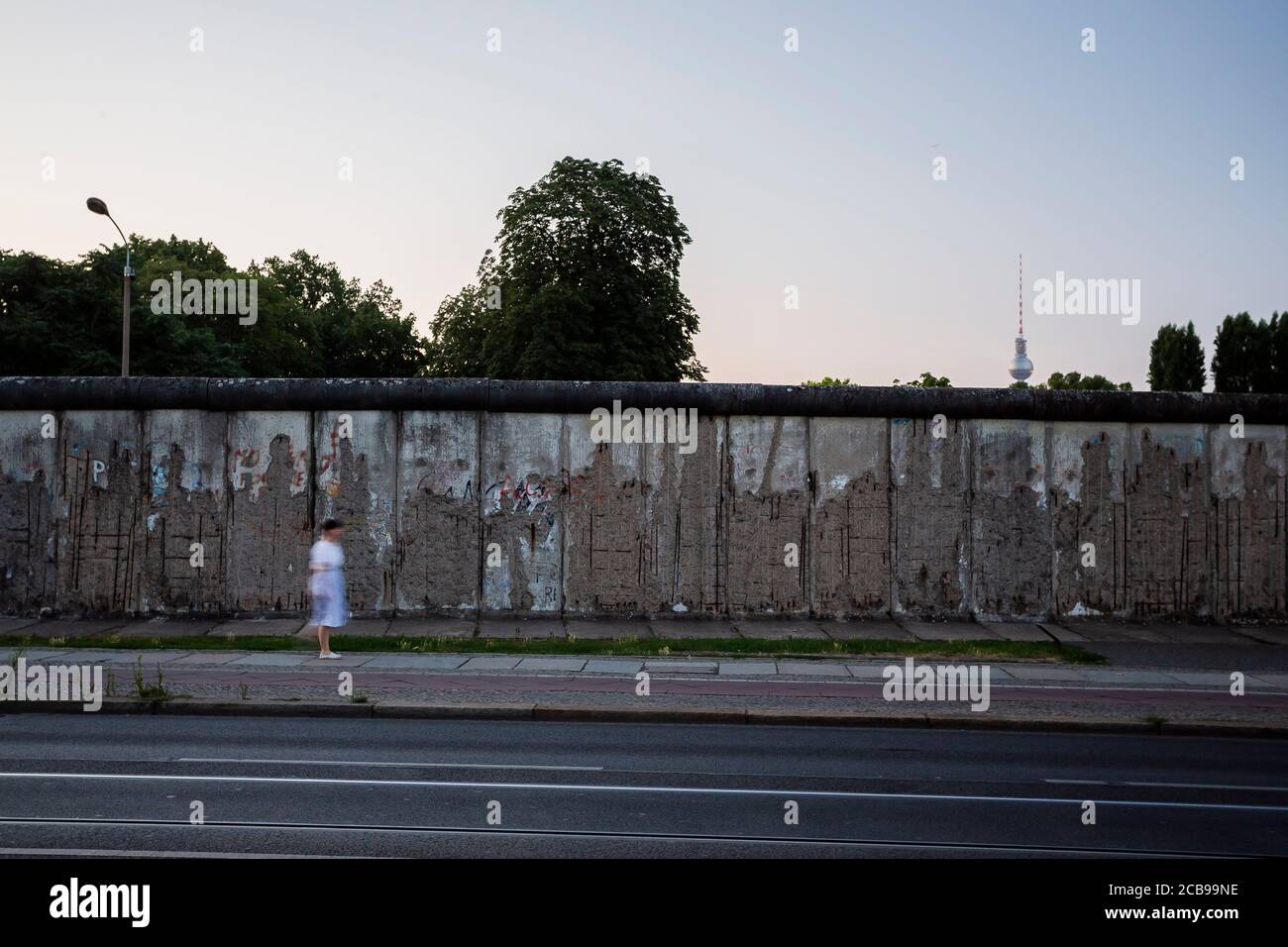 Berlin, Allemagne. 11 août 2020. Une femme marche le long de la Bernauer Strasse tôt le matin, le long du mur de Berlin. Il y a 59 ans, le 13 août 1961, la construction du mur commença, qui divisa Berlin pendant plus de 28 ans. Credit: Christoph Soeder/dpa/Alay Live News Banque D'Images