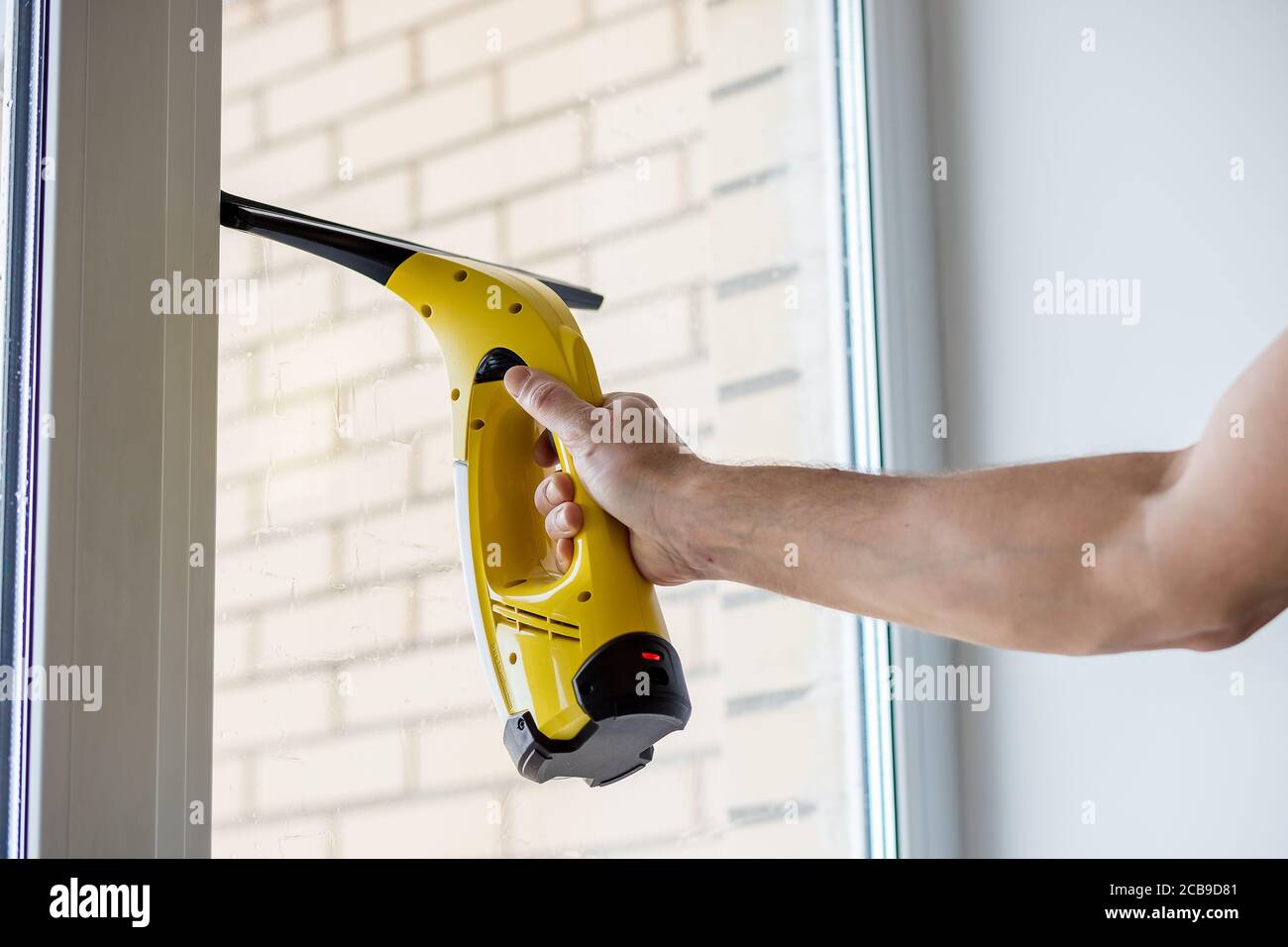 Nettoyage des fenêtres avec aspirateur.ouvrier nettoyant fenêtre en verre  de bâtiment moderne.hommes main avec avec un aspirateur électrique  professionnel portable Photo Stock - Alamy