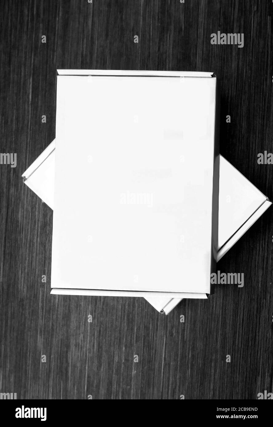 Deux boîtes en carton blanc isolées sur fond en bois foncé. Vue de dessus Banque D'Images