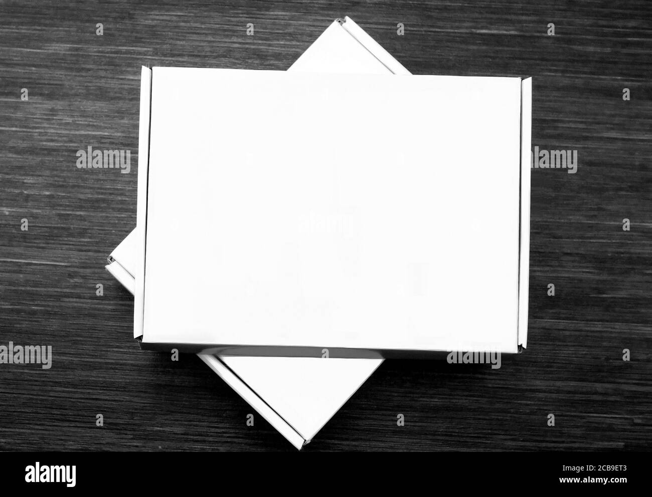 Deux boîtes en carton blanc isolées sur fond en bois foncé. Vue de dessus Banque D'Images