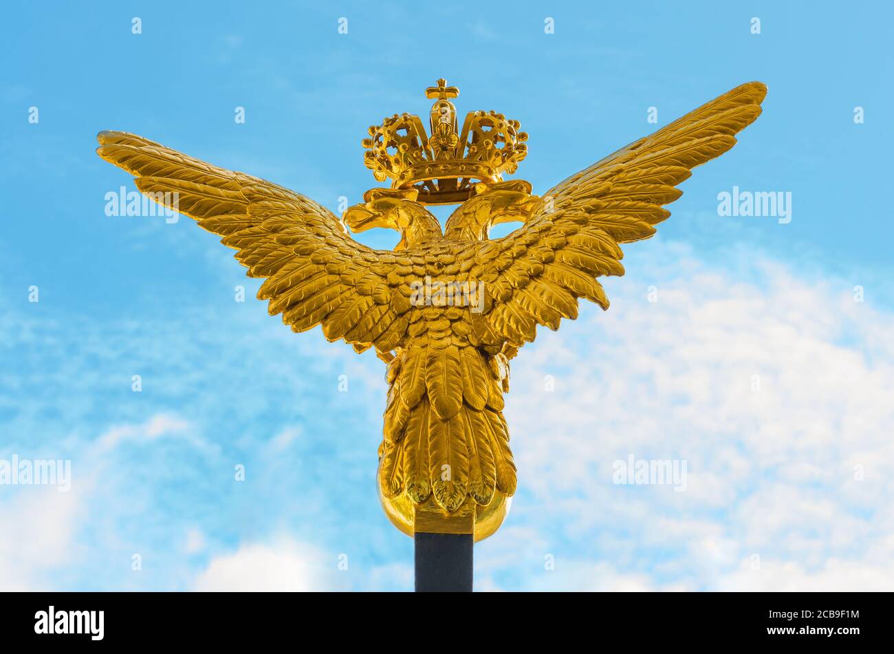 aigle doré à deux têtes sur fond bleu ciel Banque D'Images