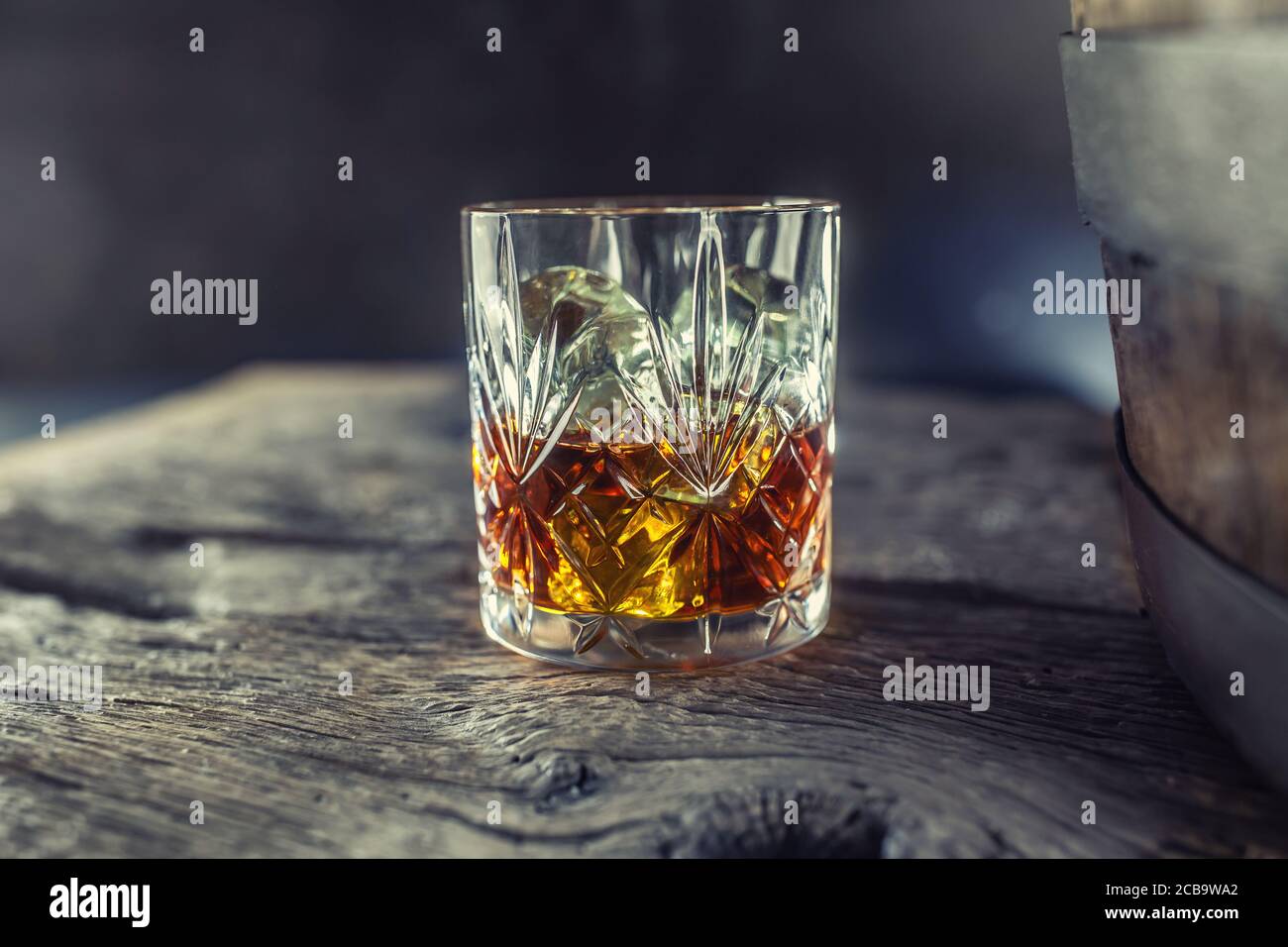 Verre au whisky rhum brandy ou bourbon sur un vieux table près d'un canon en bois Banque D'Images