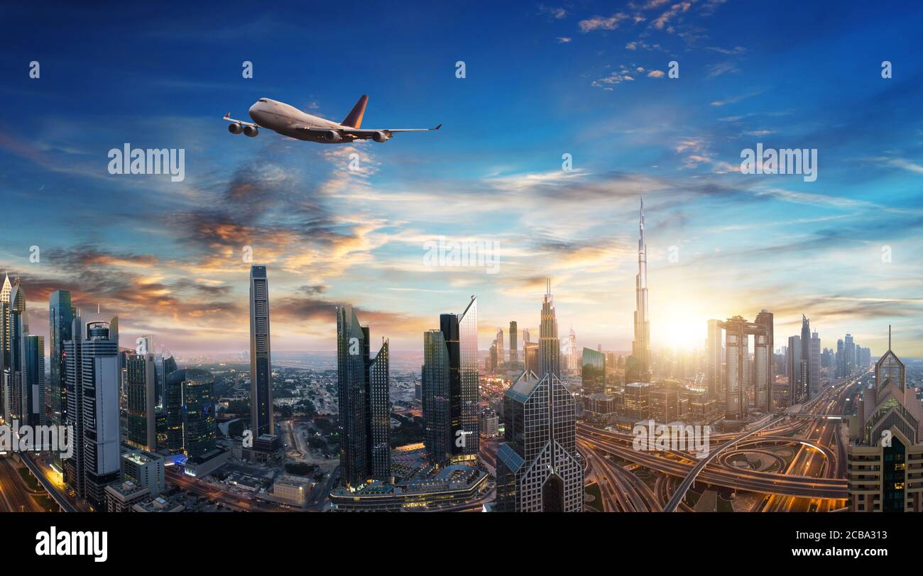 Avion commercial survolant les nuages et la ville de Dubaï, dans une belle lumière de coucher de soleil. Mode de transport moderne et le plus rapide, vie professionnelle. Très élevée Banque D'Images