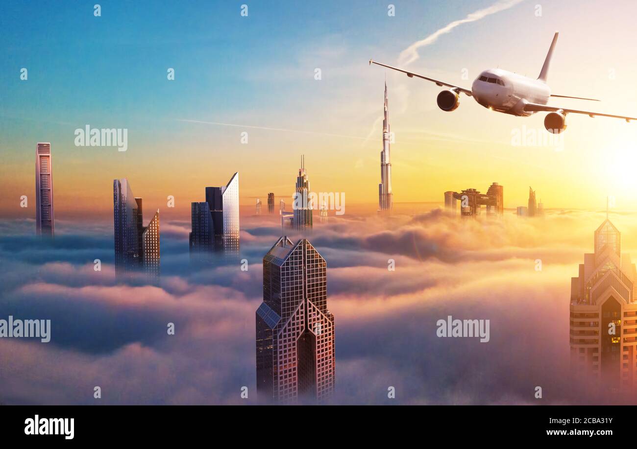 Avion commercial survolant les nuages et la ville de Dubaï, dans une belle lumière de coucher de soleil. Mode de transport moderne et le plus rapide, vie professionnelle. Banque D'Images