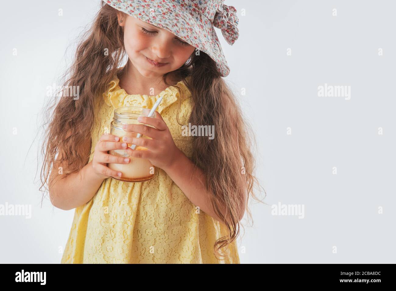 Belle petite fille avec cuillère dans la bouche en mangeant de la crème savoureuse. Manger une glace délicieuse est amusant Banque D'Images