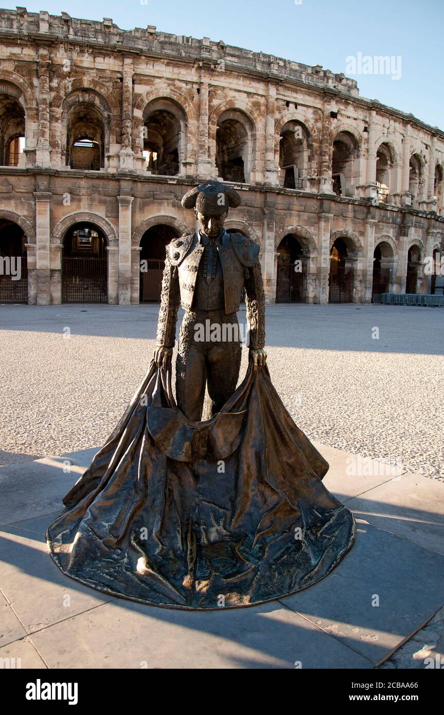 Statue de taureau, en arrière-plan l'amphithéâtre romain elliptique Nimes dans la région Languedoc-Roussillon dans le sud de la France Banque D'Images