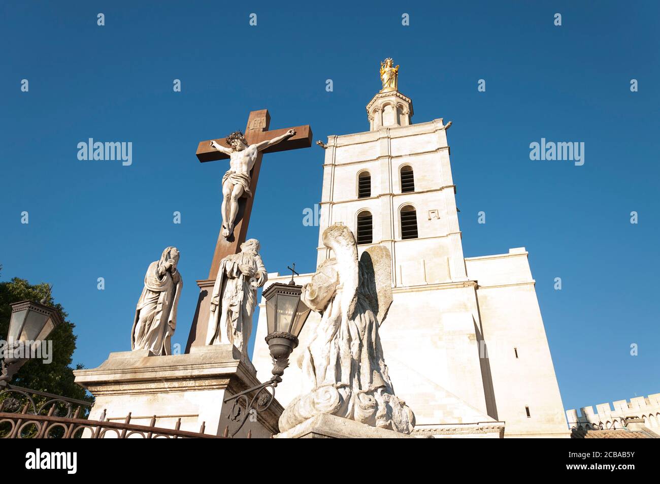 En premier plan la statue de Jésus-Christ en croix, en arrière-plan la cathédrale d'Avignon (cathédrale notre-Dame des Doms), est une ca catholique romaine Banque D'Images