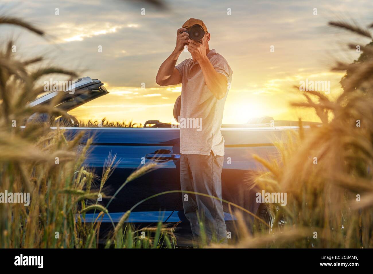 Le photographe de la nature caucasienne dans ses années 40 prend des photos de campagne restant à côté de sa voiture. Voyage en été et prendre des photos sur le chemin. Photographie Banque D'Images