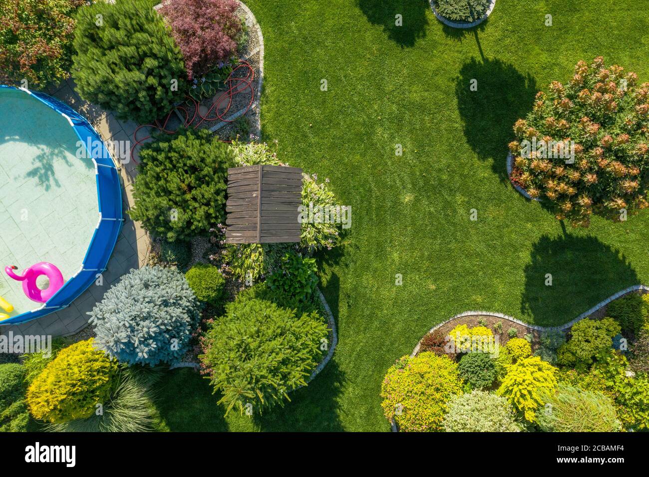 Industrie du jardinage et de l'aménagement paysager. Jardin résidentiel avec petite piscine d'en haut vue aérienne. Heure d'été. Banque D'Images