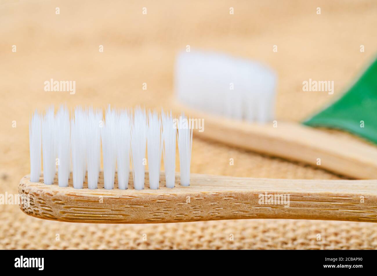 Gros plan sur la brosse à dents Bamboo avec une feuille verte sur fond de sac. Le concept écologique du produit. Banque D'Images