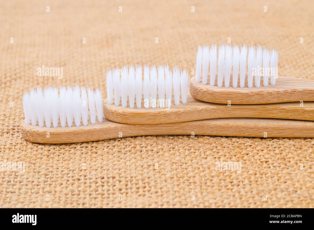 Gros plan sur la brosse à dents Bamboo avec une feuille verte sur fond de sac. Le concept écologique du produit. Banque D'Images