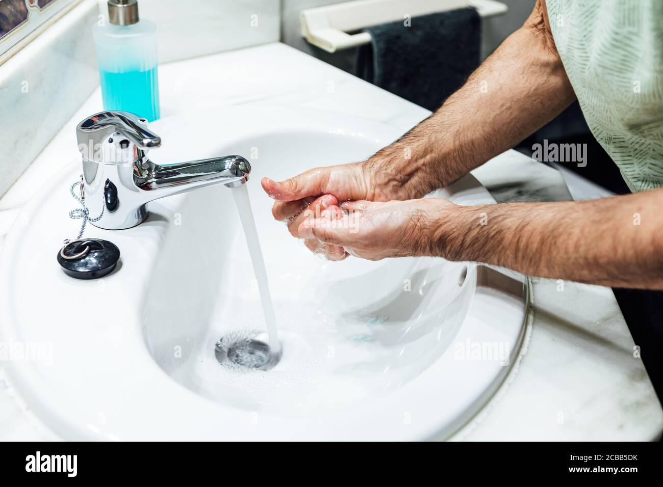 Mains d'un homme se lavant avec du savon dans la salle de bains afin de ne pas être infecté par le coronavirus. Concept Covid. Banque D'Images