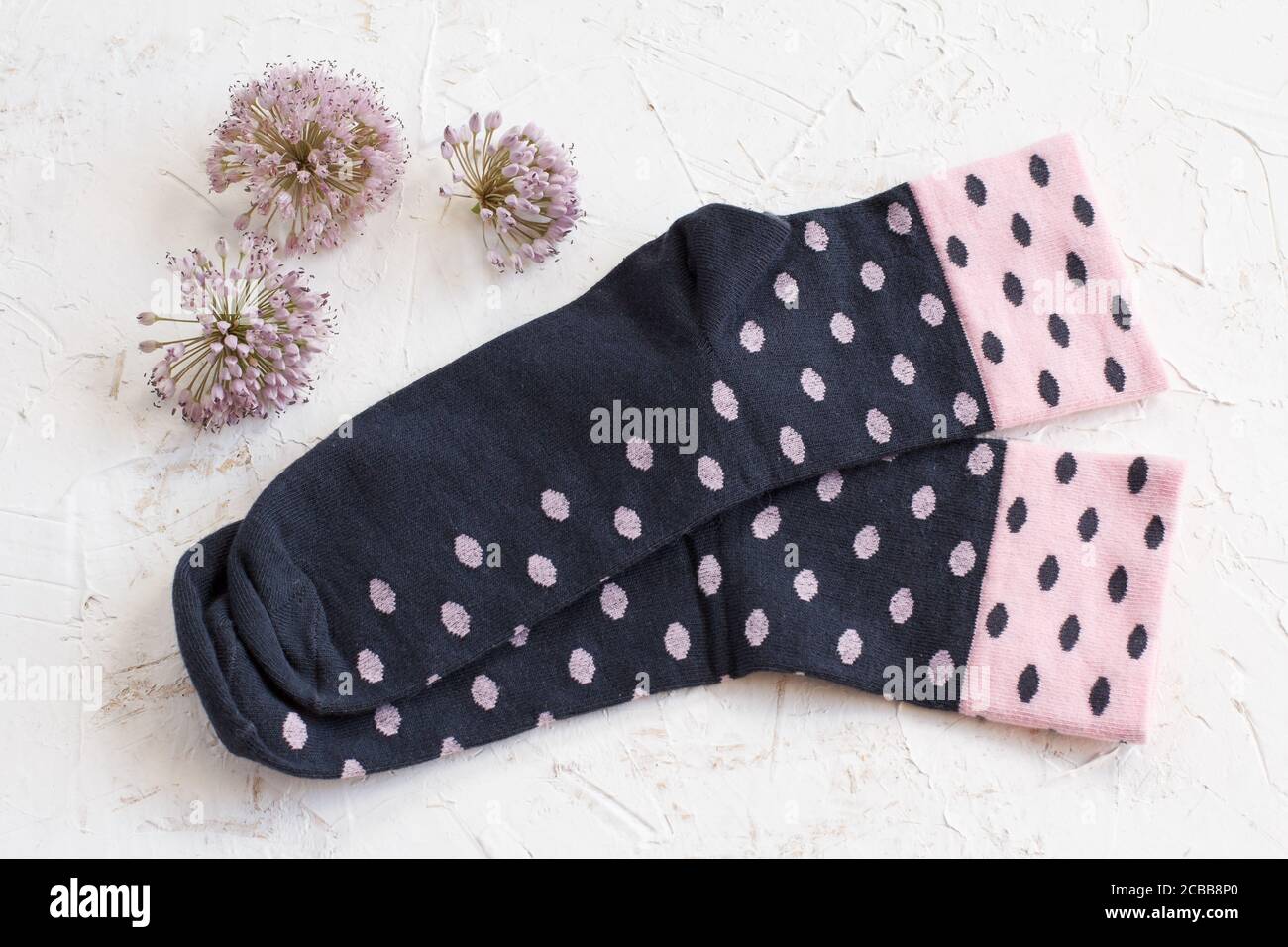 Paire de chaussettes femme et fleurs d'été sur fond blanc, vue du dessus. Banque D'Images