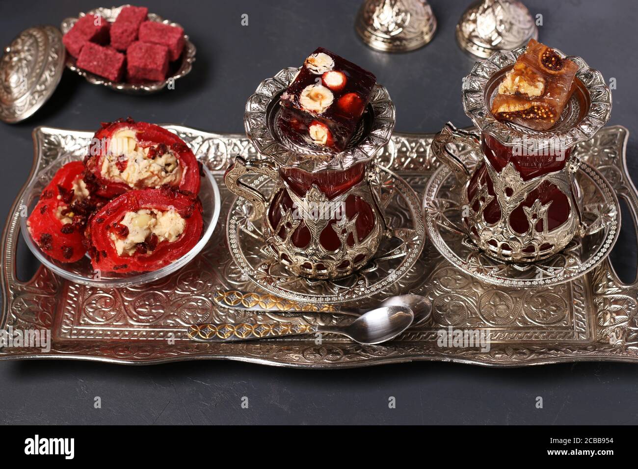 Armuds turcs avec thé et bonbons sur plateau métallique sur fond sombre, gros plan, format horizontal Banque D'Images