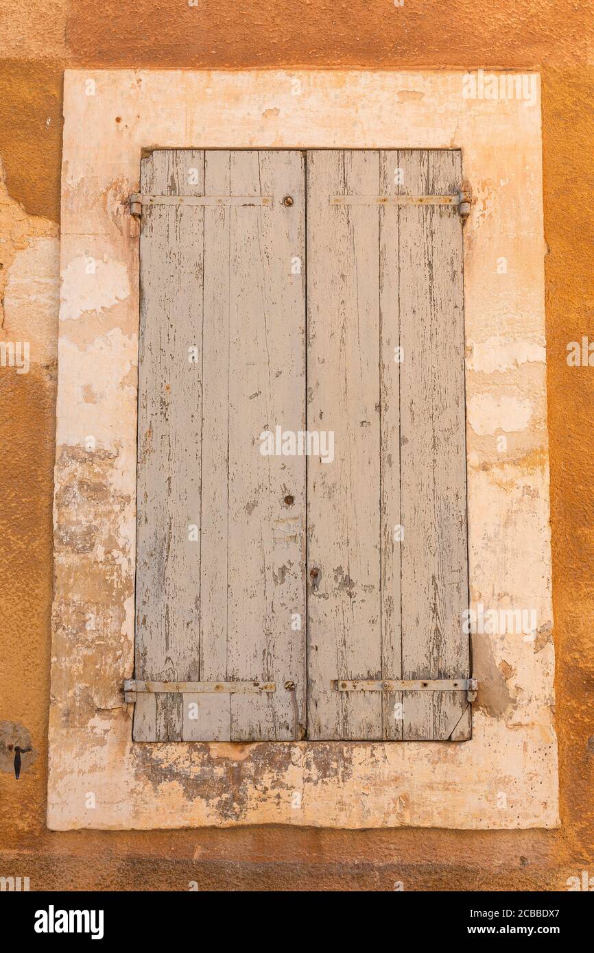 Volets contre un mur peint ocre dans le village français De Roussillon Banque D'Images