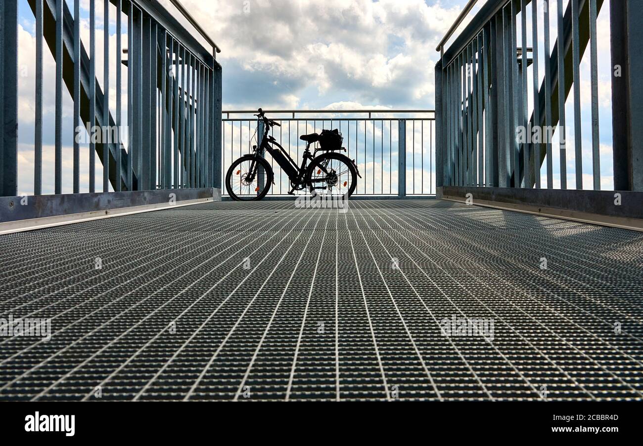 vélo électrique sur une passerelle avec un ciel spectaculaire dans le arrière-plan Banque D'Images