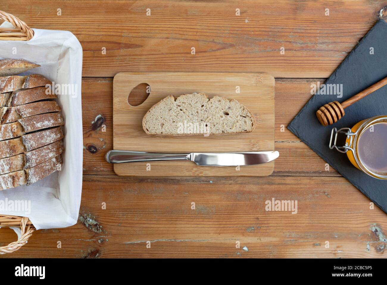 miel biologique et pain rustique sur une vieille table en bois. Petit déjeuner sain. Banque D'Images
