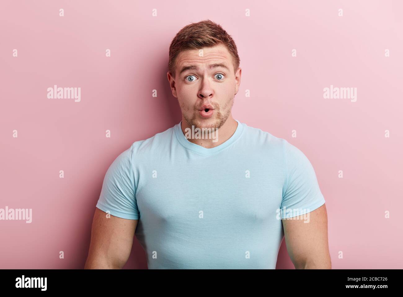 un jeune homme aux yeux d'un insecte émotif surpris portant un t-shirt bleu décontracté avec un look choqué, exprimant l'étonnement et le choc, pi isolé Banque D'Images