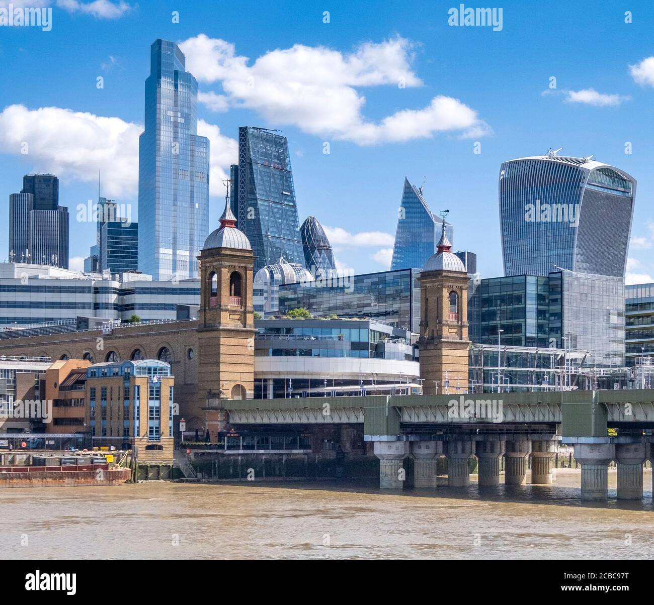 Cannon Street station, présentant des tours originales de style Wren construites dans les années 1860, avec une vue sur la ville moderne de Londres derrière elle. Banque D'Images