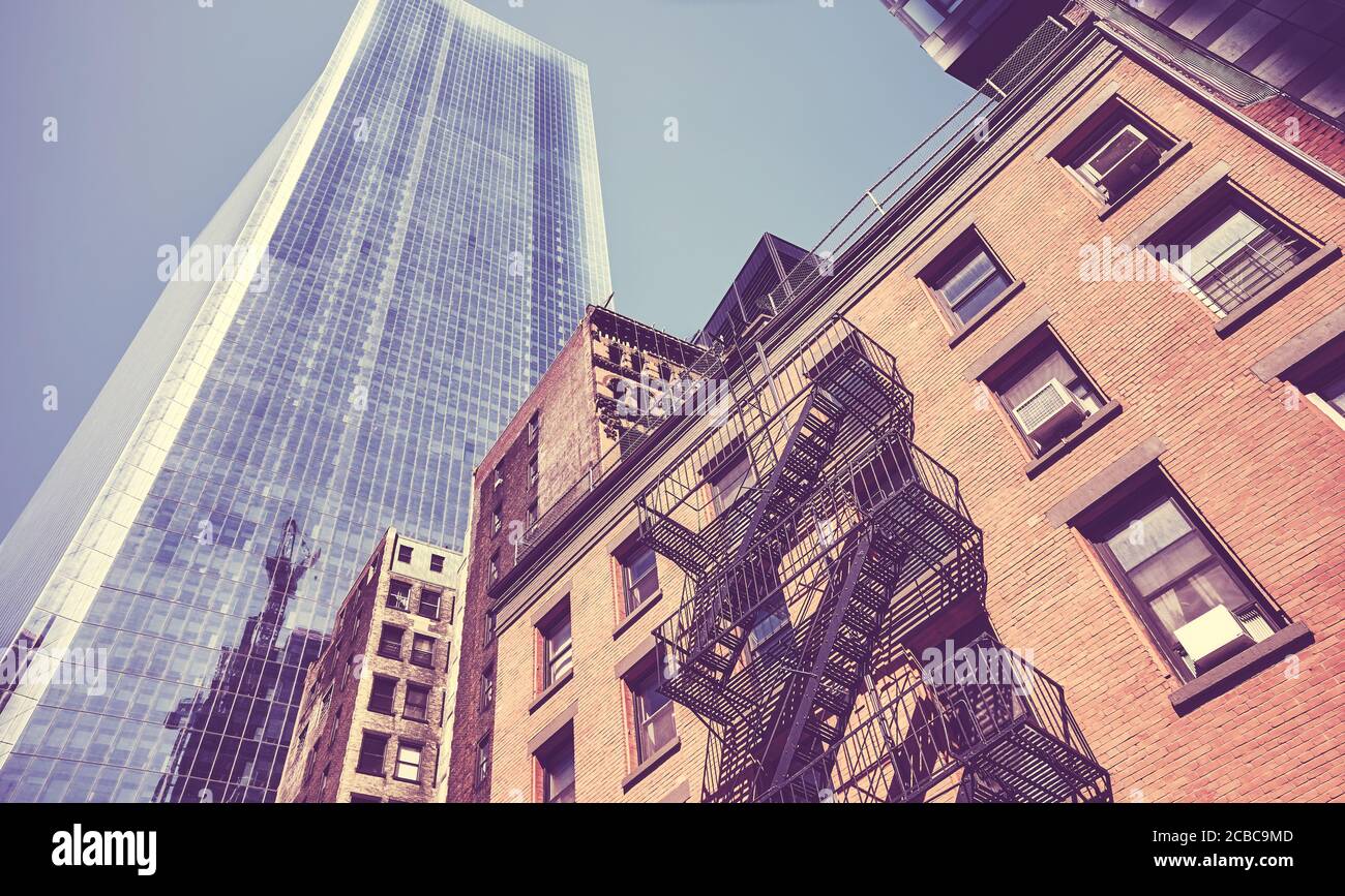 Image aux tons vintage de vieilles maisons de tenement avec gratte-ciel moderne à distance à New York City, États-Unis. Banque D'Images
