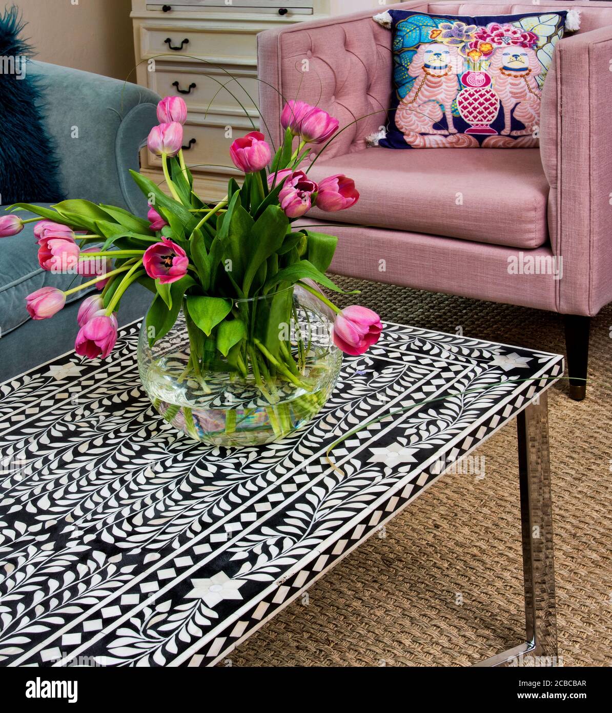 Table basse en mosaïque noire et blanche avec tulipes roses Vase Banque D'Images