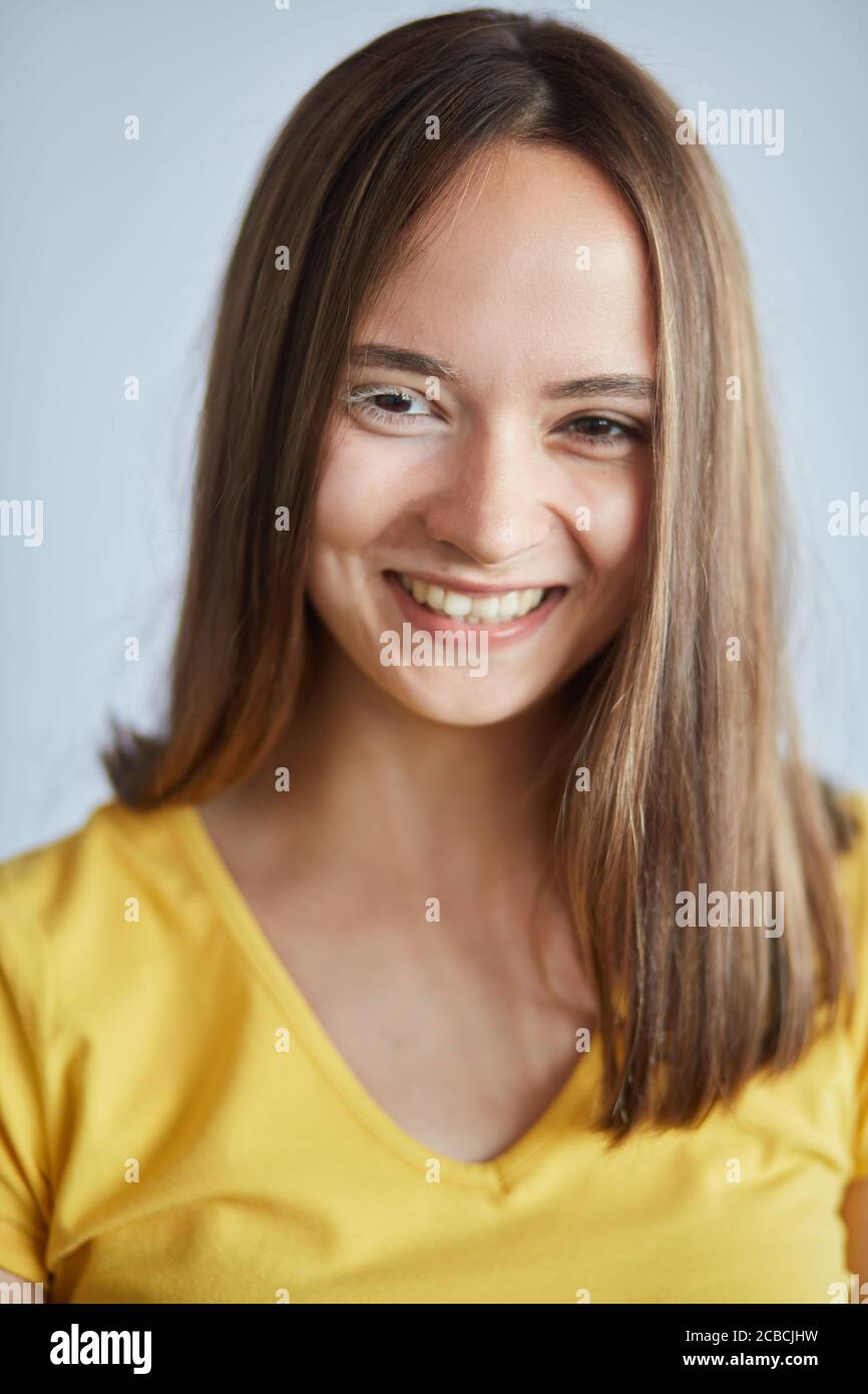 Souriante gaie fille en T-shirt jaune, exprime l'émotion positive, photo de gros plan. Bonheur Banque D'Images