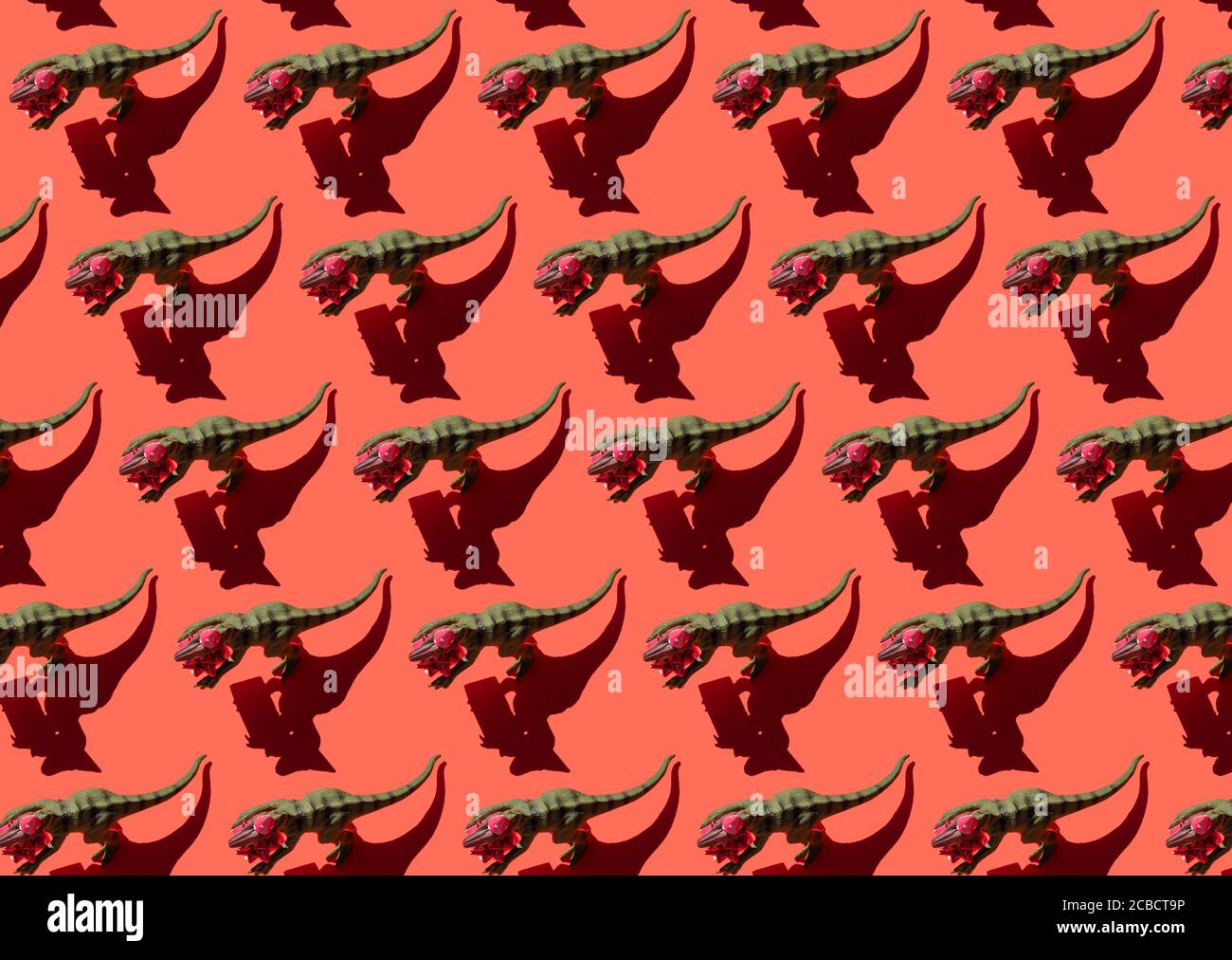 Dinosaure avec motif boîte cadeau sur fond rouge Banque D'Images