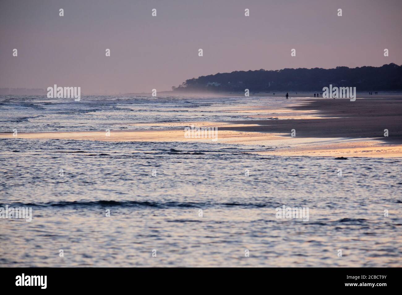 Couleurs douces du coucher de soleil d'hiver sur une plage de Hilton Head Island se reflète dans les vagues qui se précipitent pour se couvrir le sable Banque D'Images