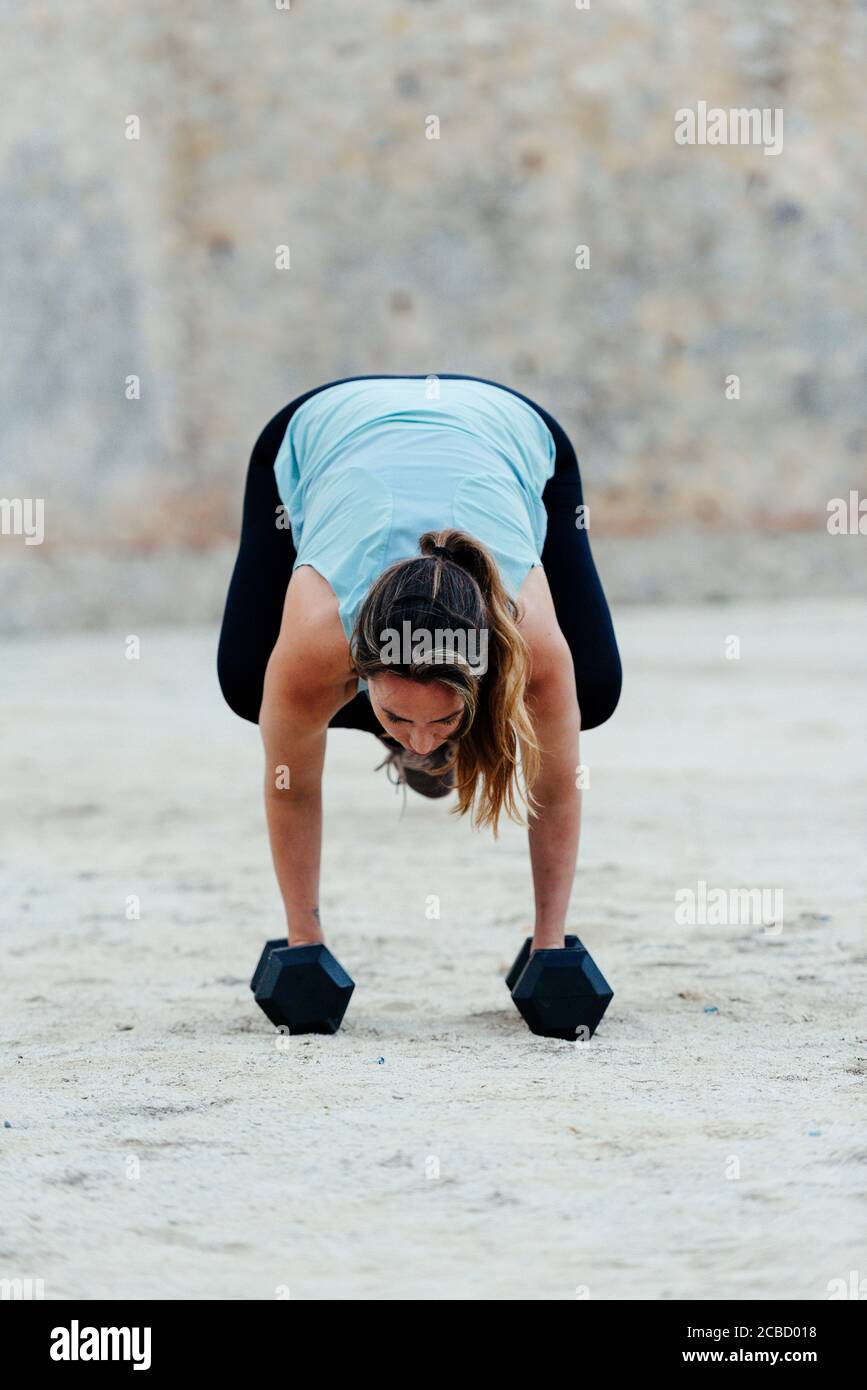 Jeune femme qui fait des positions de yoga en milieu urbain. Banque D'Images