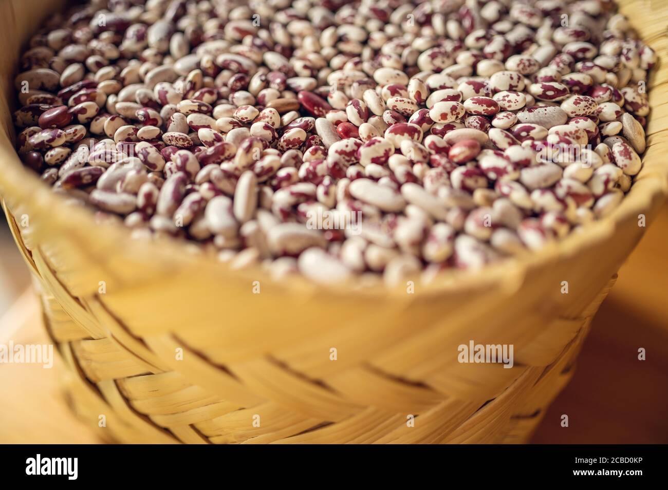 Haricots mexicains exotiques colorés sur panier en osier. Vue de dessus des légumineuses Banque D'Images