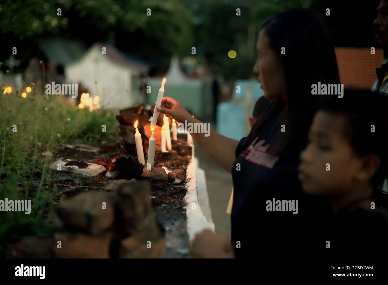 Larantuka, Indonésie. 2 avril 2015. Des dévotés catholiques éclairant des bougies au cimetière de la cathédrale le jeudi Maundy, dans le cadre des célébrations de la semaine Sainte à Larantuka, sur l'île de Flores, en Indonésie. Banque D'Images