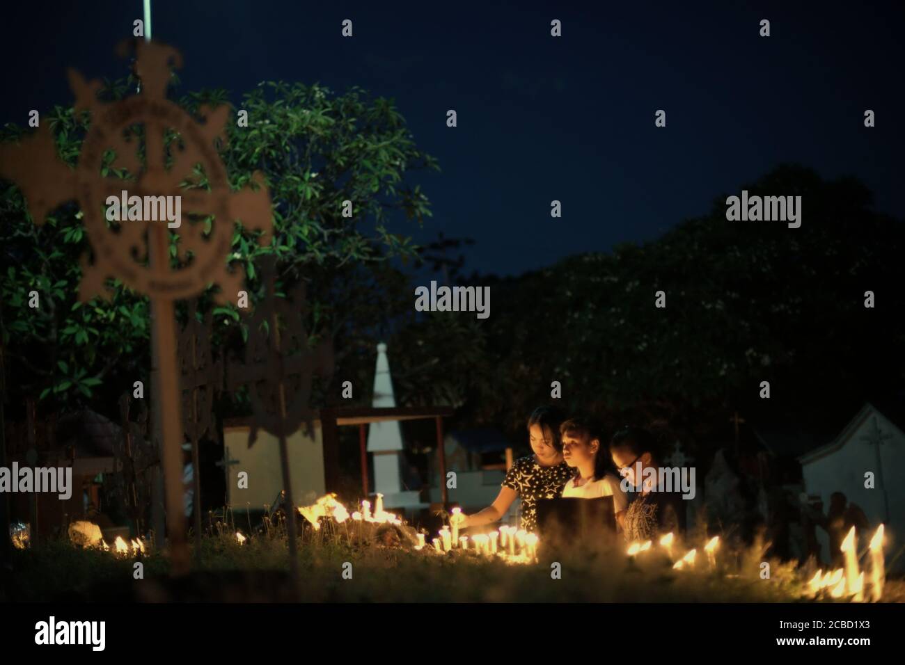Larantuka, Indonésie. 2 avril 2015. Des dévotés et des pèlerins catholiques éclairant des bougies au cimetière de la cathédrale le jeudi Maundy, dans le cadre des célébrations de la semaine Sainte à Larantuka, sur l'île de Flores, en Indonésie. Banque D'Images