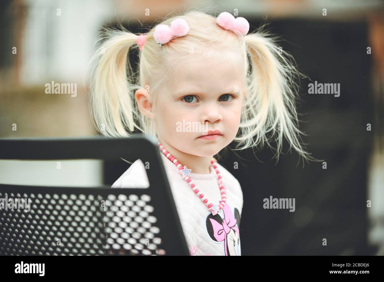 Portrait d'une jeune fille belle assise sur une chaise dans le parc Banque D'Images