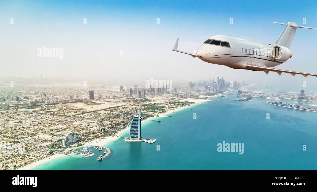 Jet Privé avion volant au-dessus de la ville de Dubaï en beau coucher de la lumière. Hôtel moderne et le mode de transport le plus rapide, la vie de l'entreprise. Banque D'Images