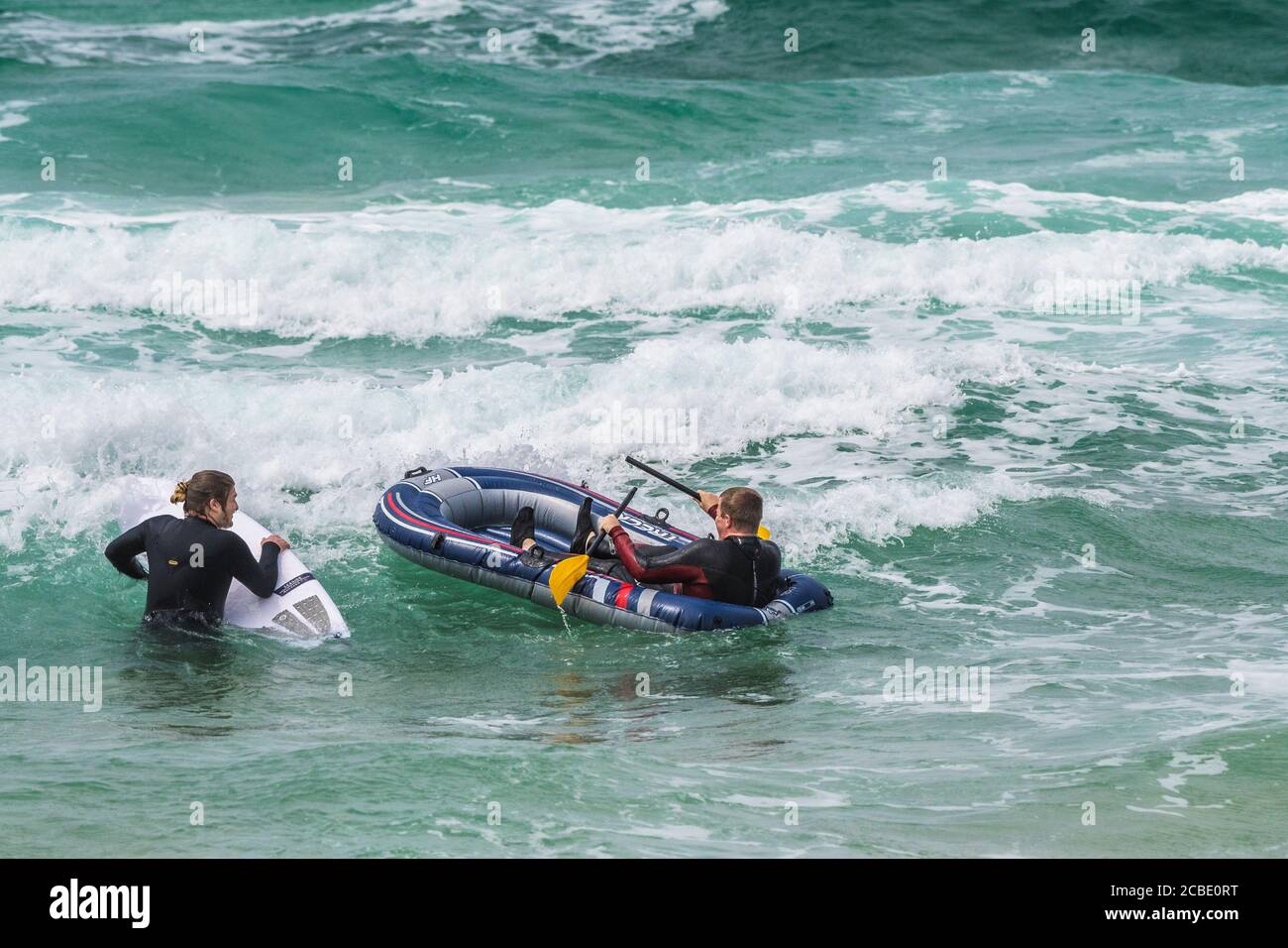 Un holidaymaker assis dans un canot pneumatique dans la mer à Fistral Beach à Newquay en Cornouailles. Banque D'Images