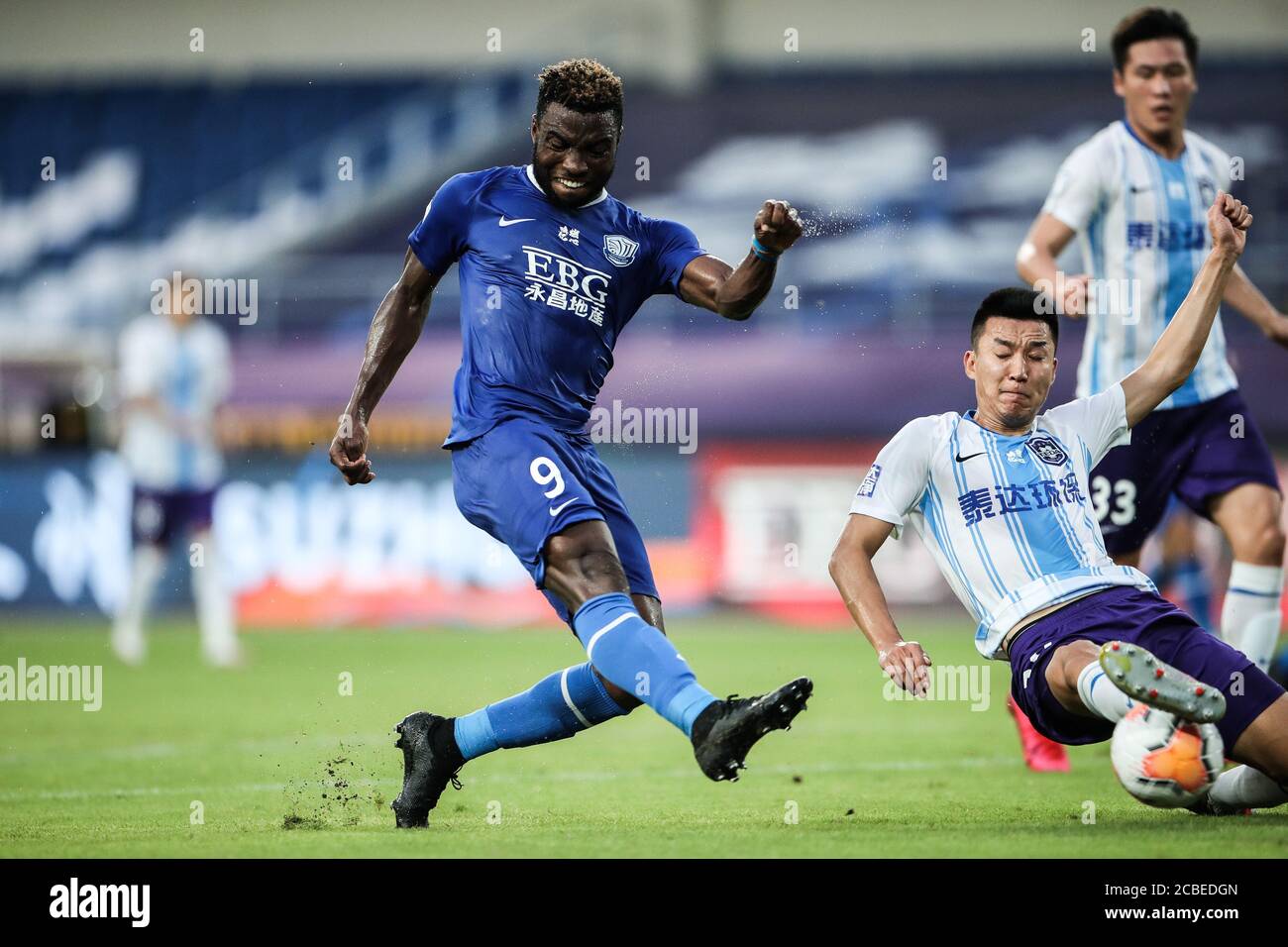 Le joueur de football congolais Oscar Maritu ou Oscar de Shijiazhuang toujours brillant F.C., à gauche, tire lors du quatrième tour du match de la Super League chinoise (CSL) 2020 contre Tianjin TEDA F.C., ville de Suzhou, province de Jiangsu en Chine orientale, 11 août 2020. Le F.C. de Shenzhen a cassé le F.C. de TEDA de Tianjin avec 3-0. Banque D'Images