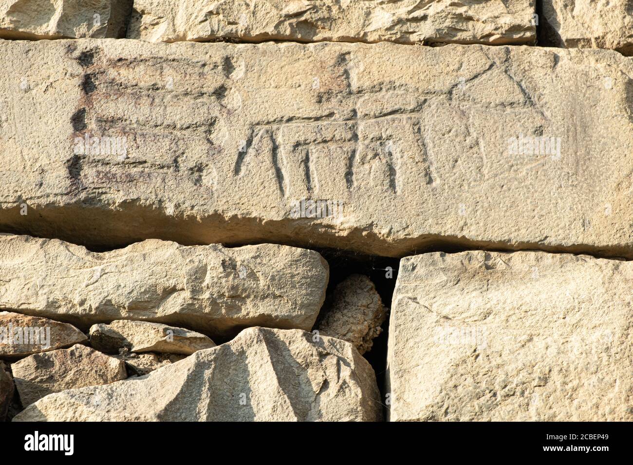 Pétroglyphes anciens sur les murs en pierre d'une ancienne maison Banque D'Images
