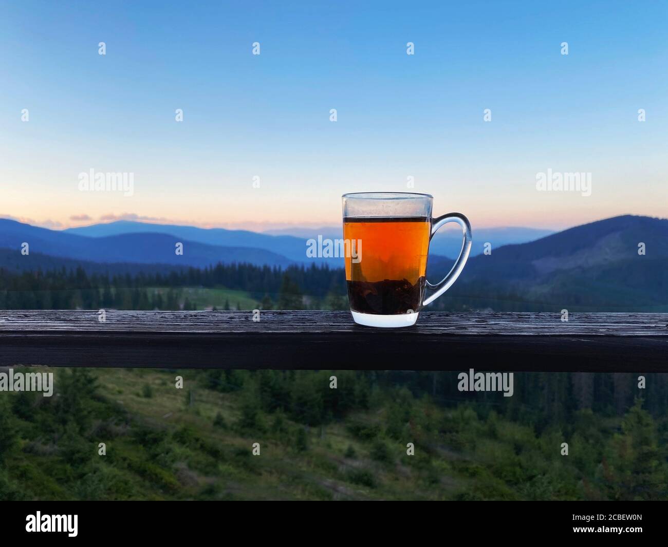 Verre de thé sur les montagnes carpathes vue au lever du soleil. Ukraine, Dragobrat Banque D'Images